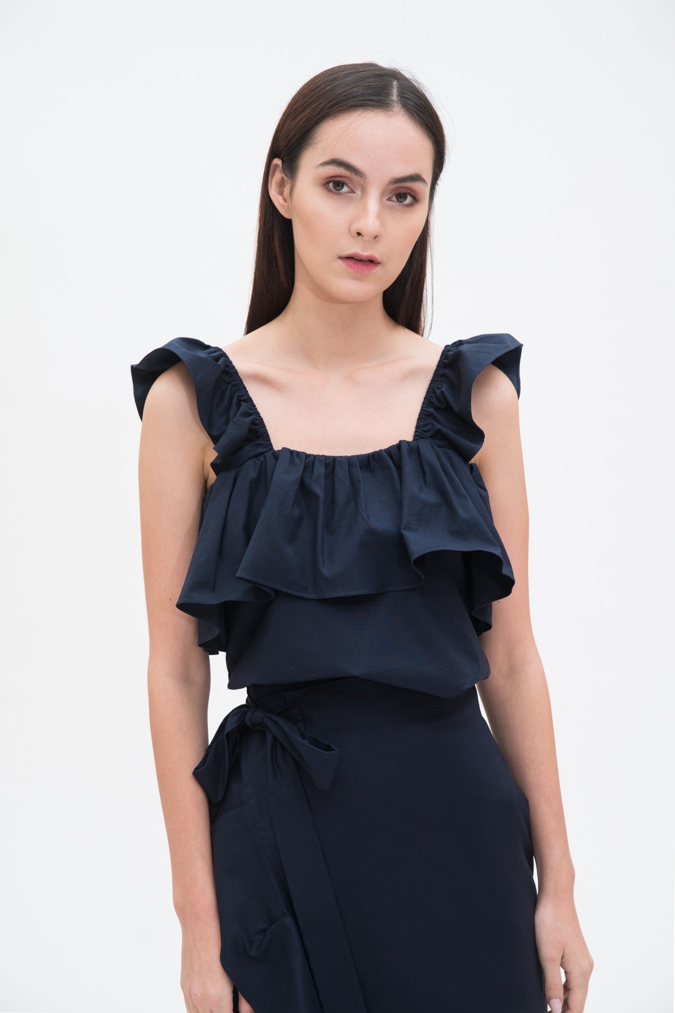 A woman is wearing a blue ruffled scrappy dress
