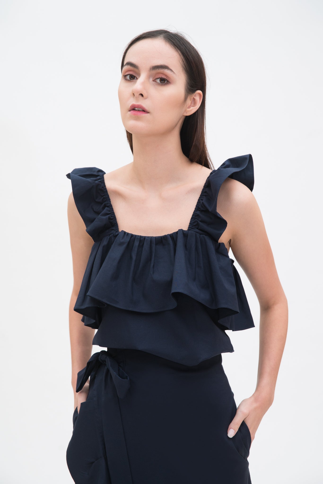 A woman is wearing a blue ruffled scrappy dress