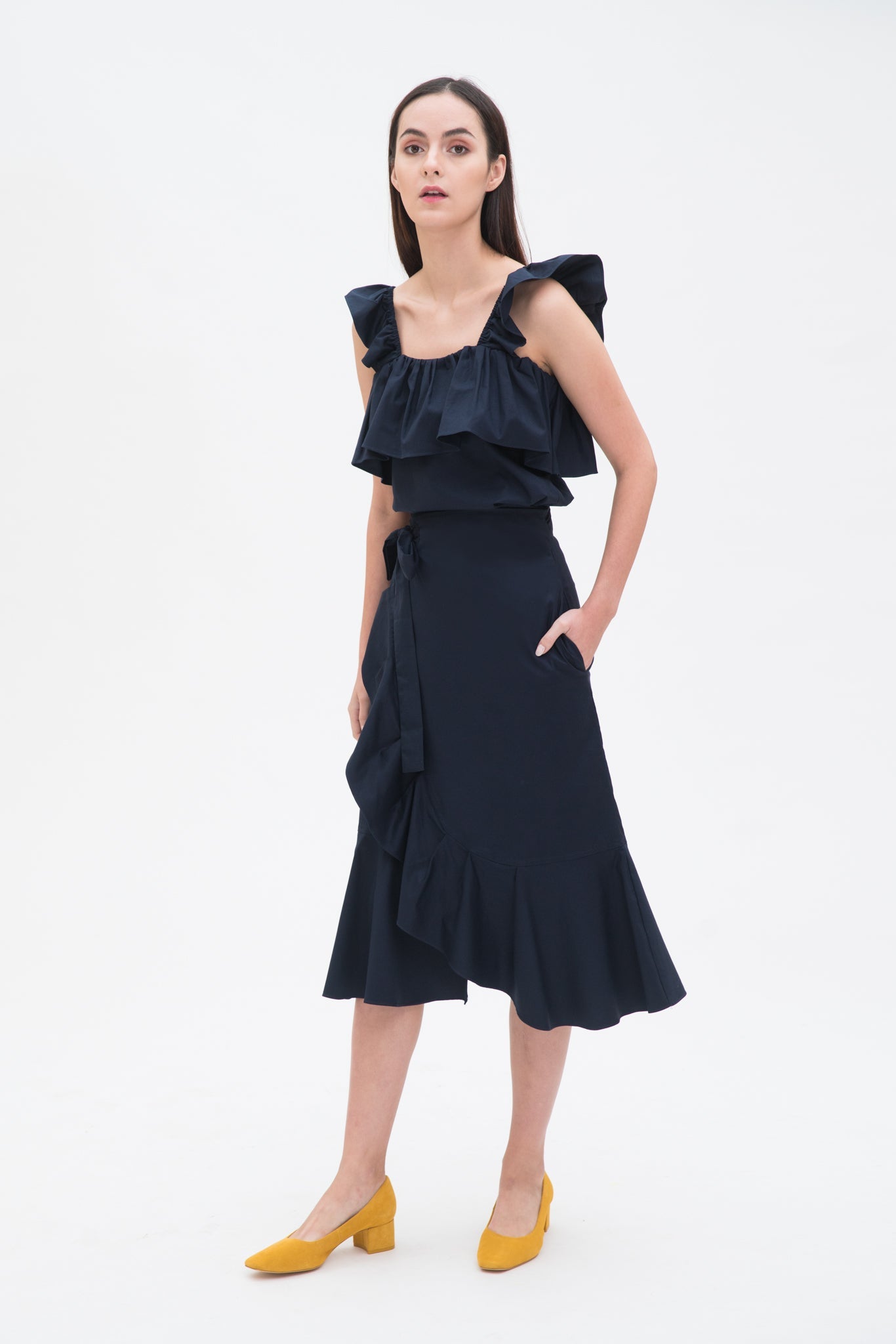 A woman is wearing a blue ruffled scrappy dress