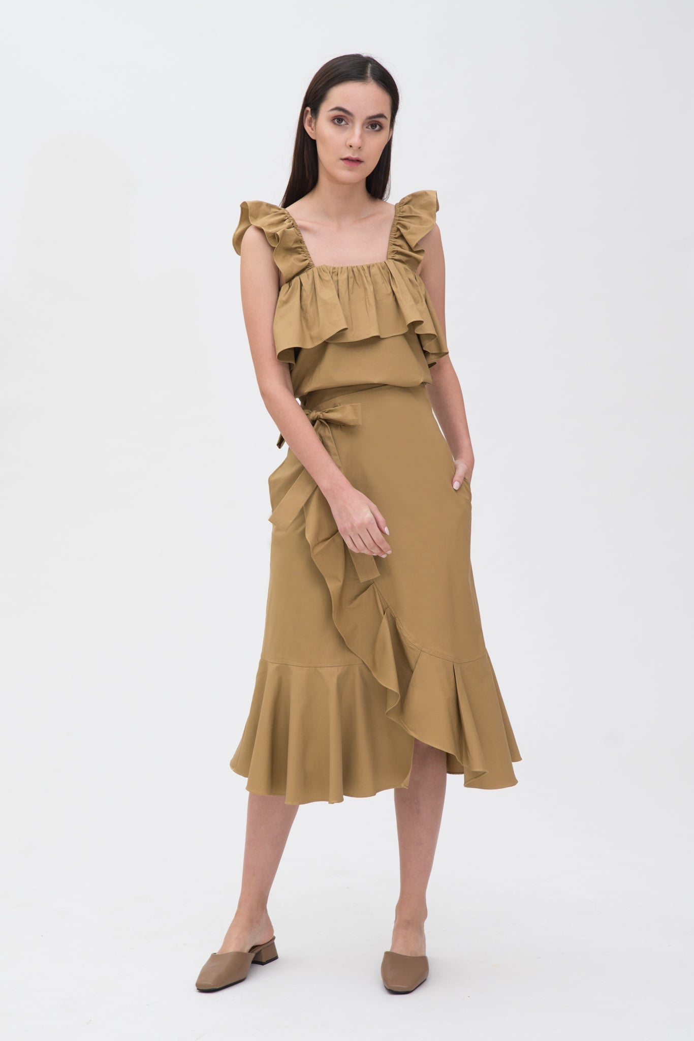 A woman is wearing a camel ruffled scrappy dress.