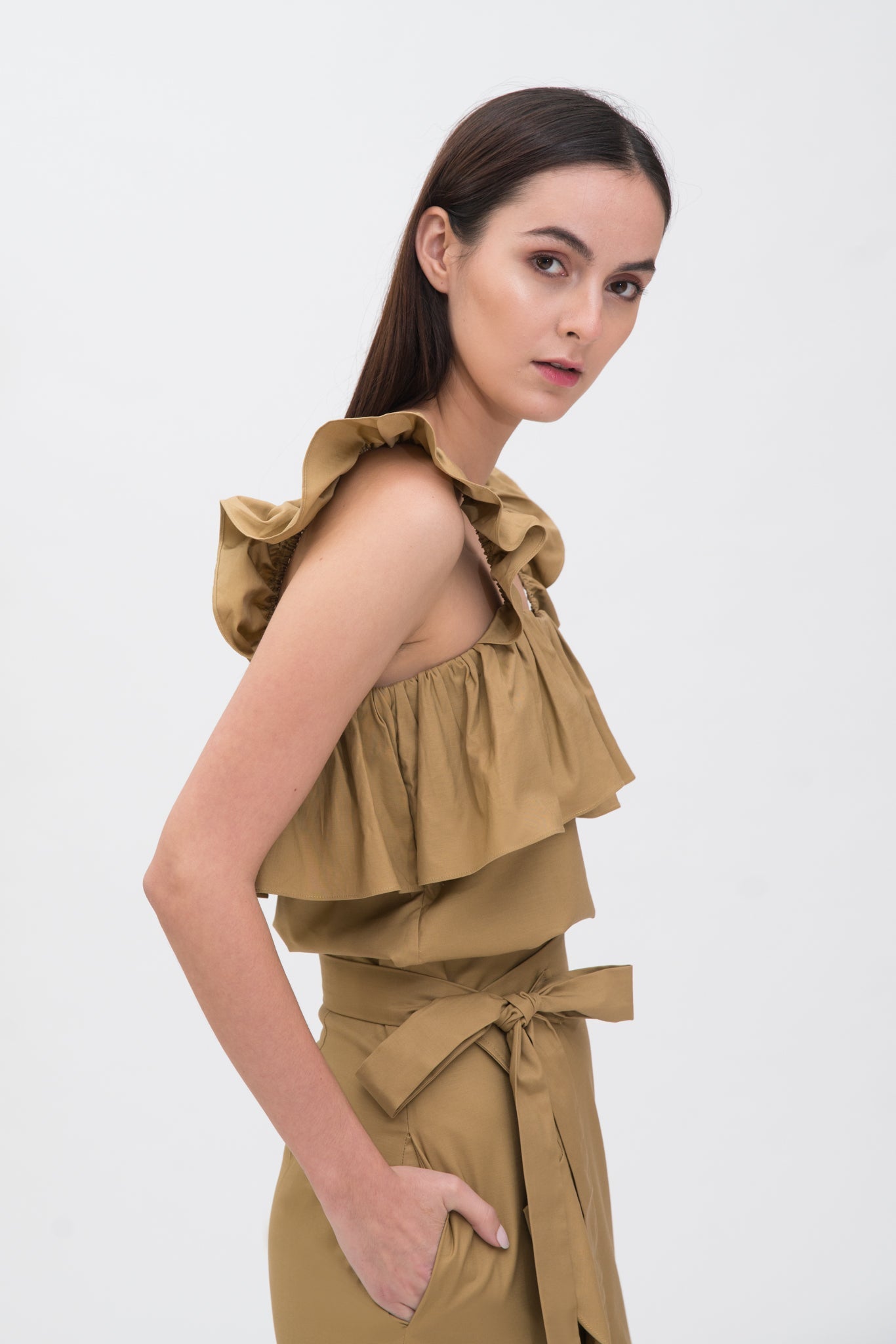 A woman is wearing a camel ruffled scrappy dress.
