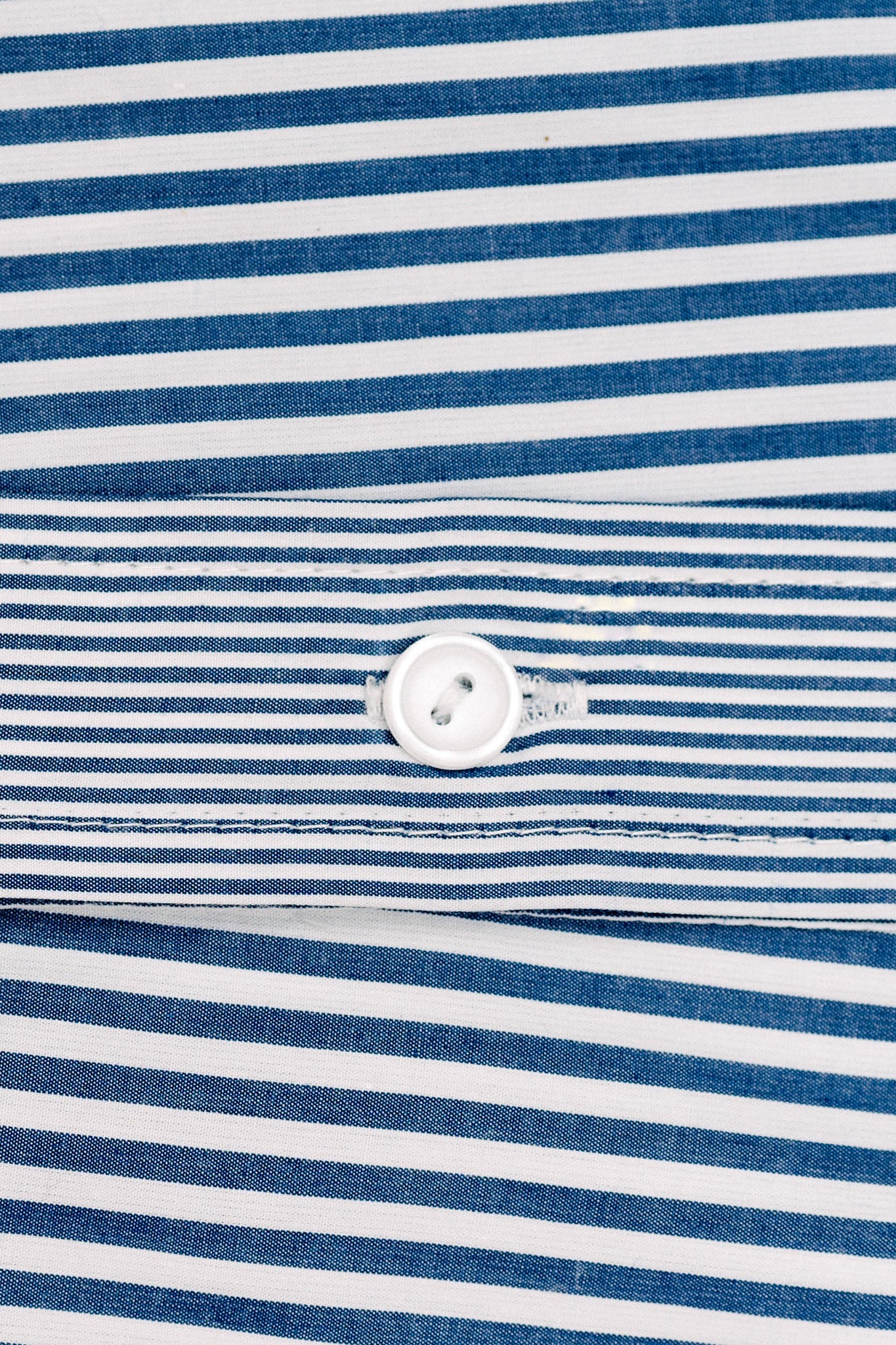 A close up of blue and white striped material and a white button