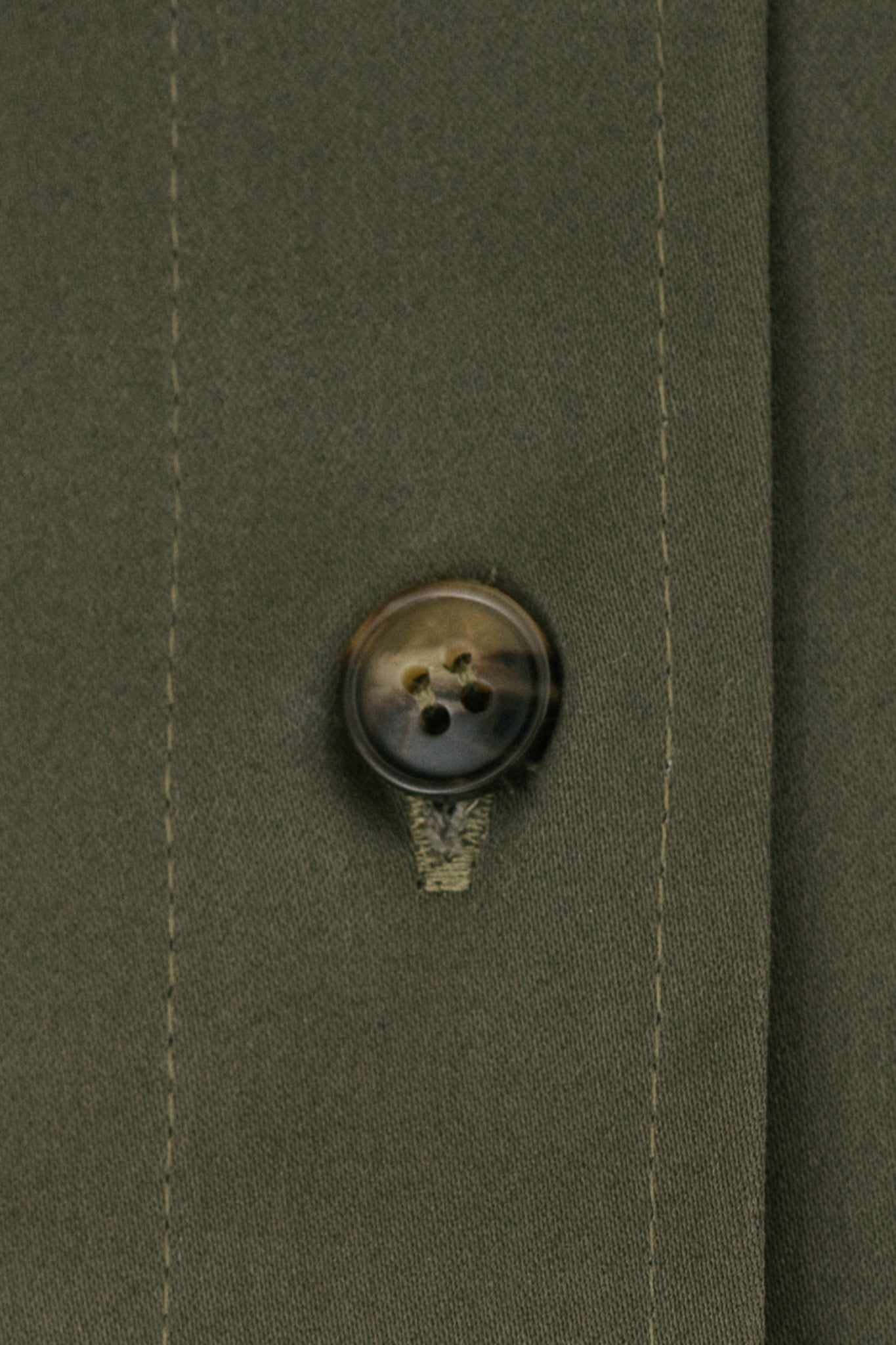 A close up of green fabric and a brown button