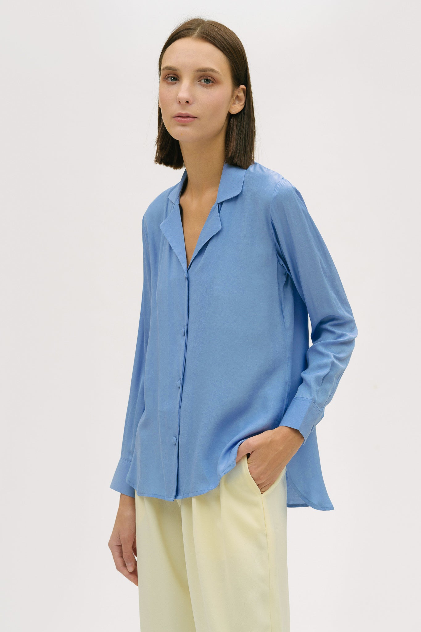 A woman is wearing a blue shirt and yellow trousers.
