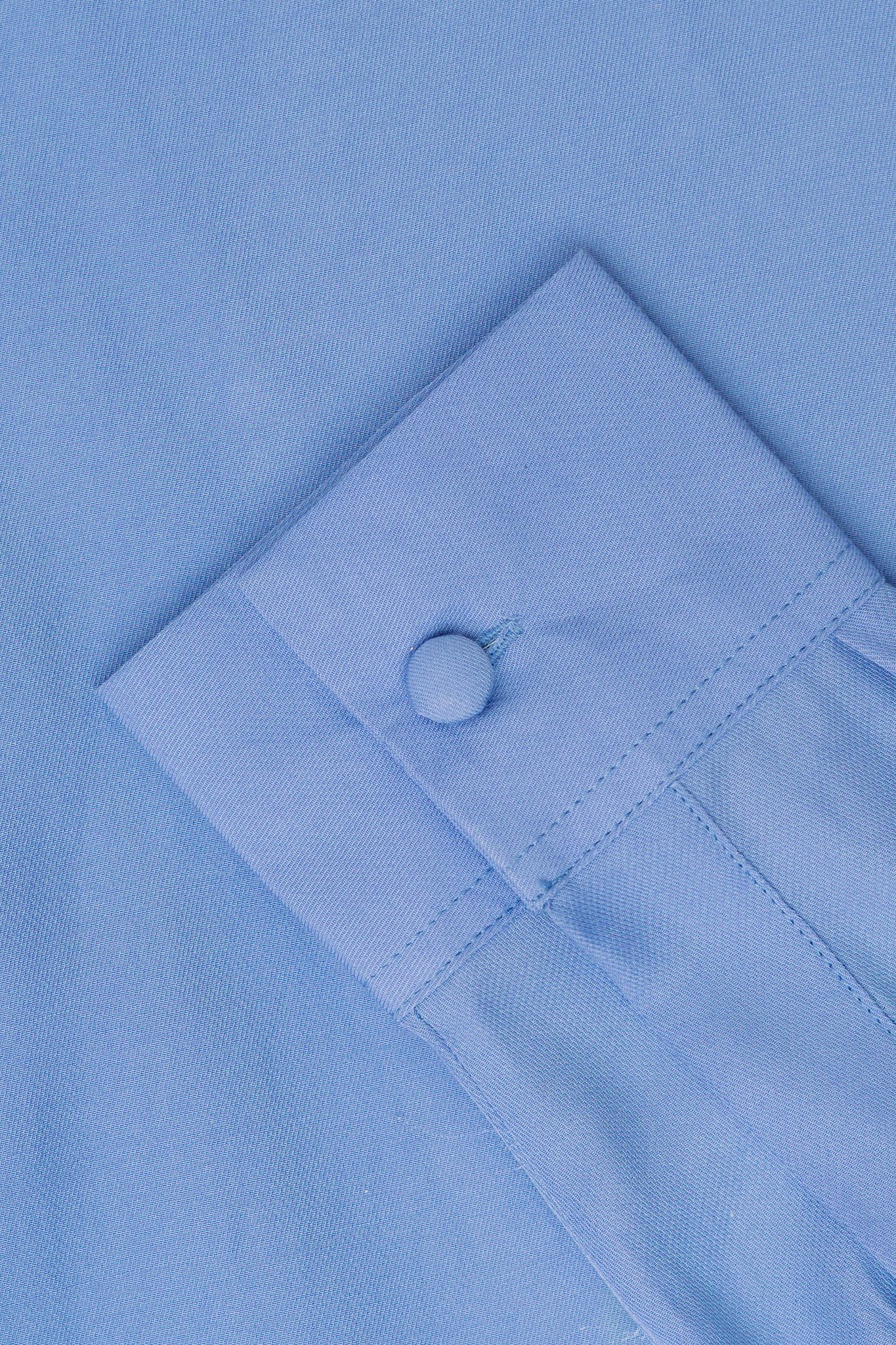 A close up of blue fabric and a blue button