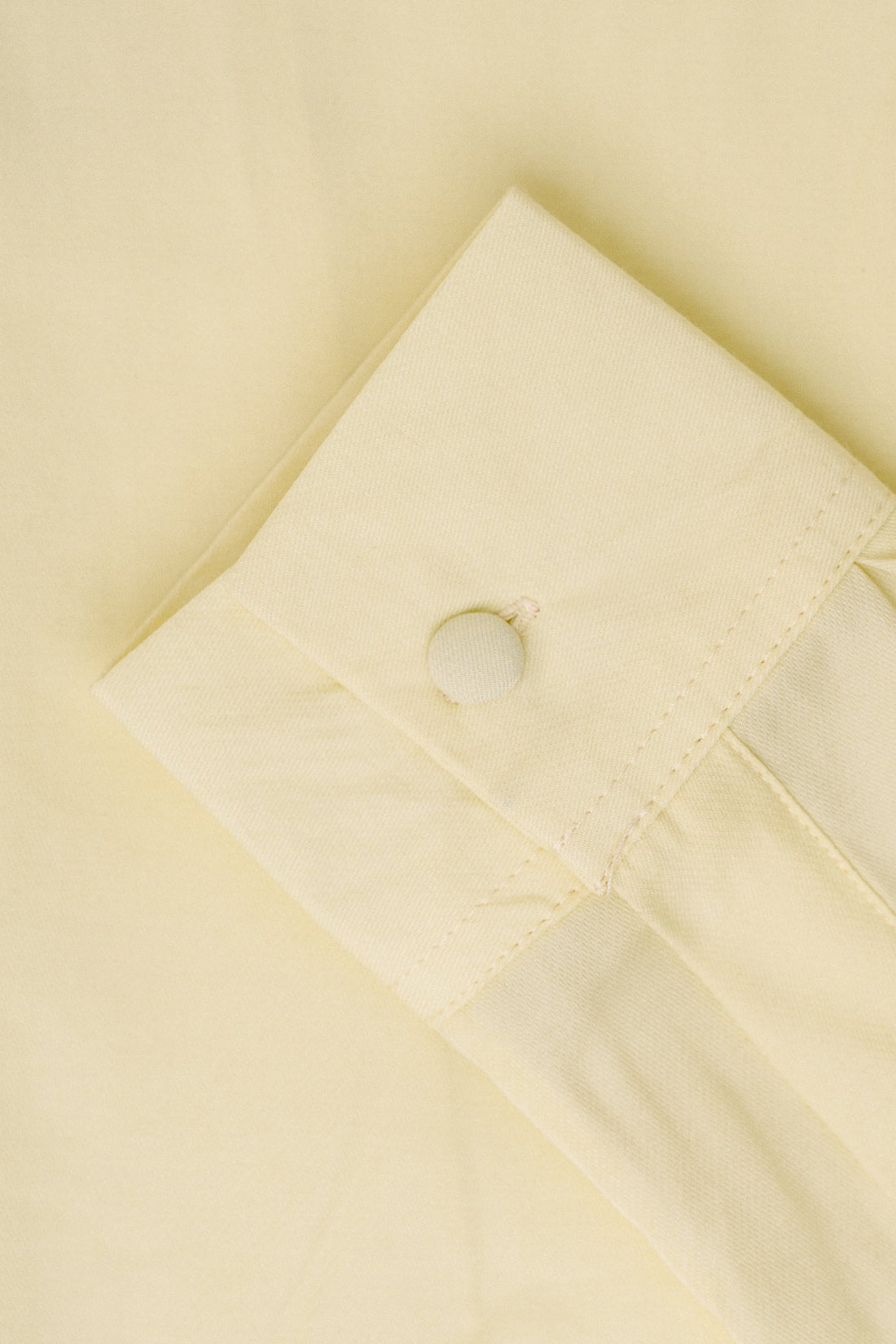 A close up of yellow fabric and a yellow button